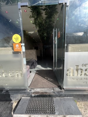 Glass door with metal handle on left side. Push to open.
