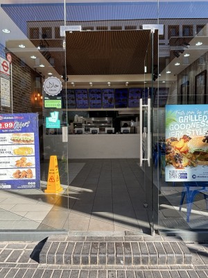 From sidewalk facing venue entrance, single glass door with metal door handle on left hand side, push to open. Glass walls on either side of door