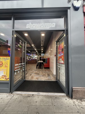 From street facing venue. Grey glass doors. Long metal handle in centre. Push to open.