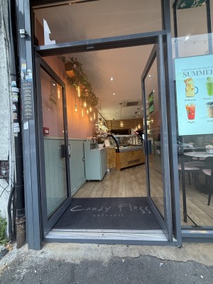 From street facing venue. 1 step up to venue. Grey glass doors. Metal handle in centre. Push to open.