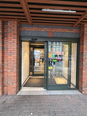 Glass doors with metal frame ahead. Left door slides automatically to right to open.
