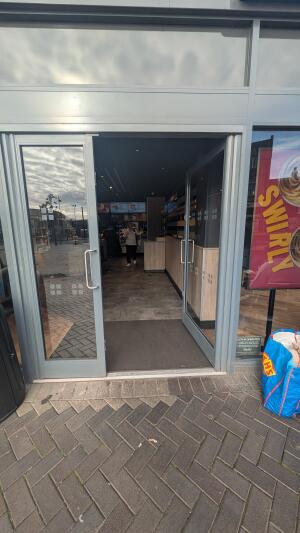 Glass door with metal frame. Push handles in center to open