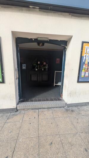 Glass doors with wooden frames. Push handles in center to open.