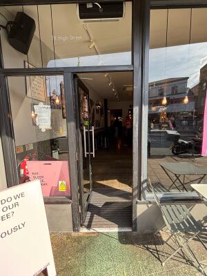 Glass door with metal frame ahead. Push via handle on right to open.