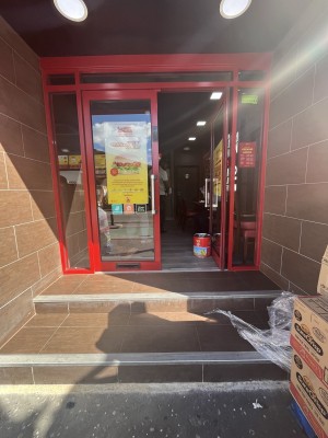Glass double door with a red frame. Handle in centre. Push to open.