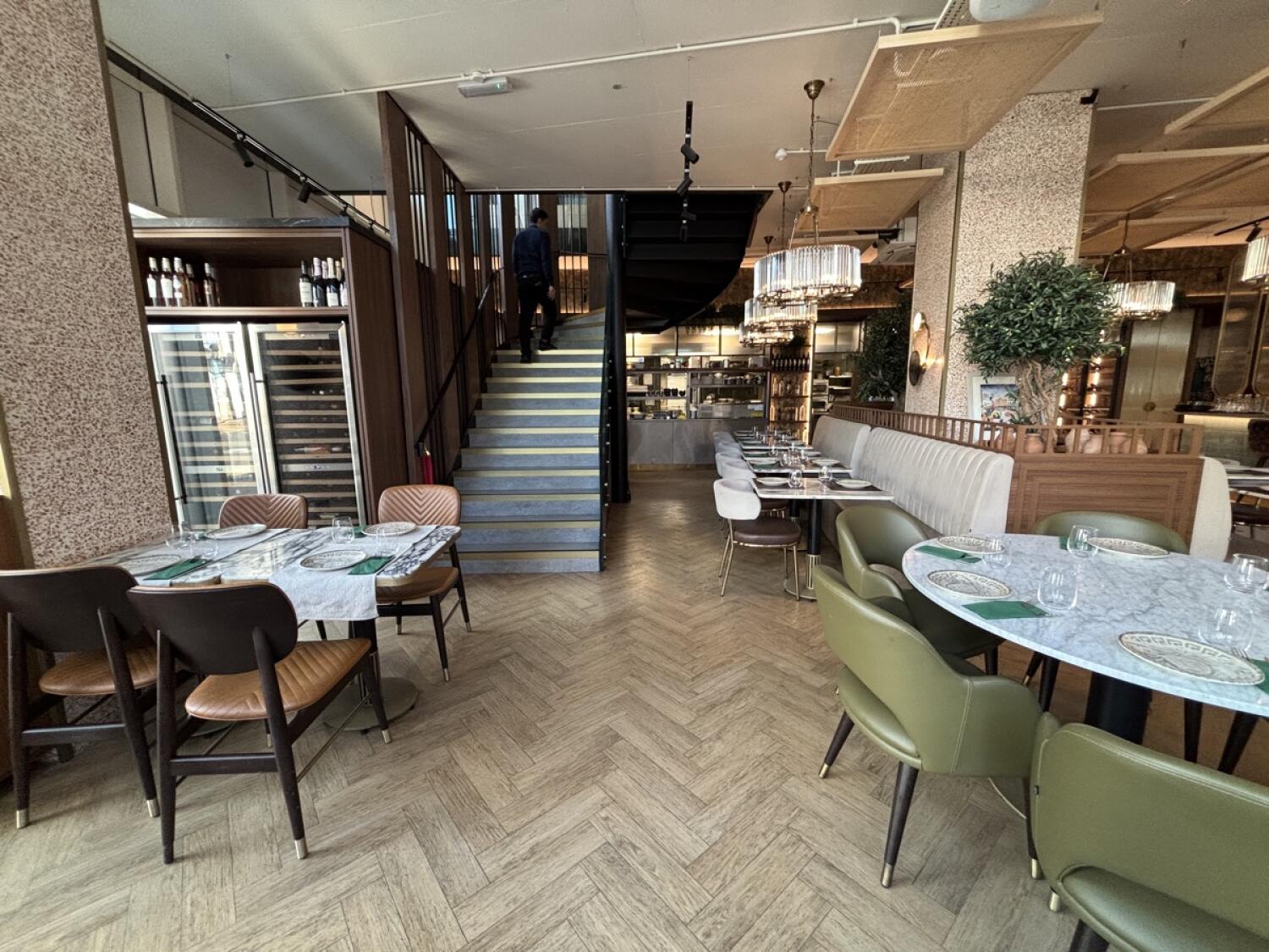 From end of path facing right. Tables on both sides. Stairs to upstairs on back left. Half booth with tables and chairs along back right.