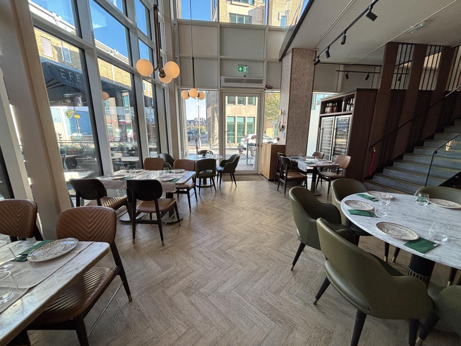 From column facing straight. Tables and chairs along left. Path down center to door to outdoor space on back. Table on right.