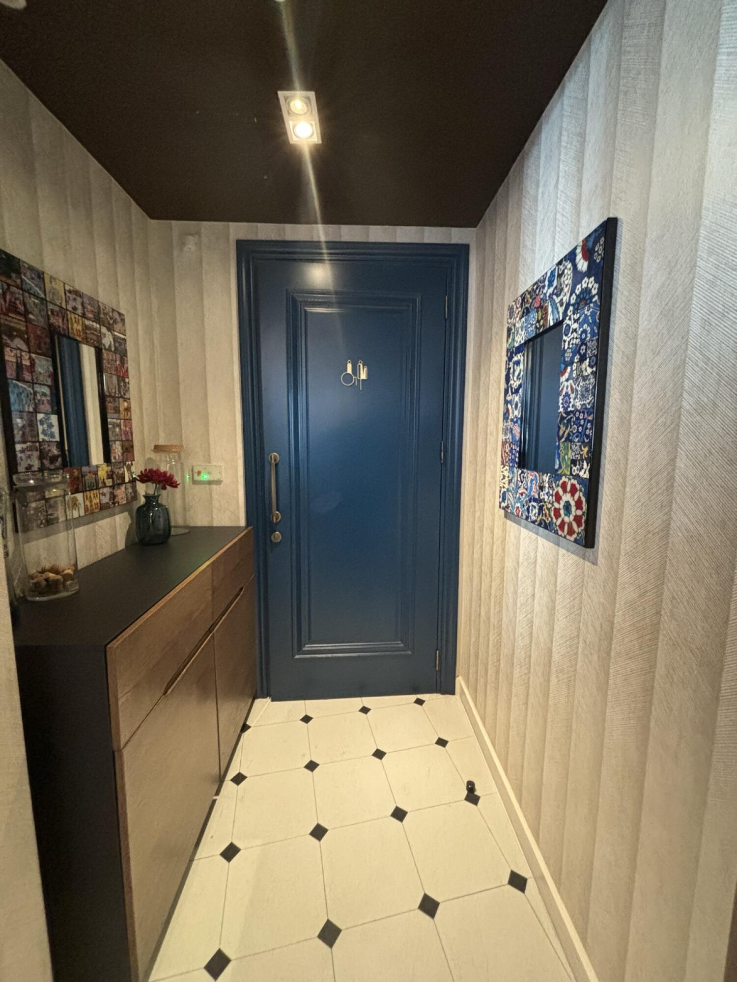 From baby high chairs facing left. Shelving along left. Blue wooden bathroom door at back. Pull from handle on left to open.