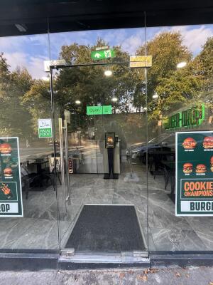 Glass door with handle on left. Push to open.
