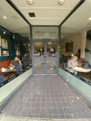 Grey framed glass door. Silver metal handle in centre. Pull to open.