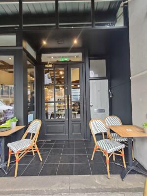 From sidewalk, facing venue. Seating on both sides. Doorway at back.