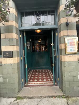 Green double door with handles in middle. Push sideways to open.