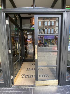 Black framed glass door. Push from centre to open. Doorway behind to second door.