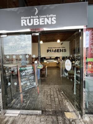 Glass double door with metal handles in centre. Push to open.