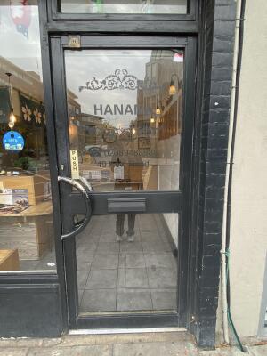 Black framed glass door. Black metal handle on left side of door. Push to open.
