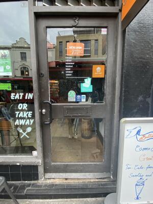 Black framed glass door. Black metal handle on left side of door. Push to open.