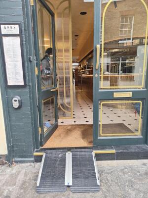 Green framed glass door ahead. Push golden handle in centre to open.