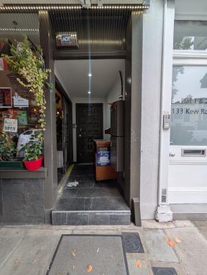 Grey frame archway in front. Stand on behind on right. Doorway to indoor space on left behind.