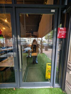Grey frame glass doors in front. Metal handle on left. Pull to open.