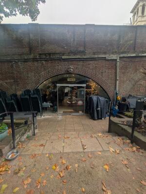 From sidewalk facing venue. Steps to entrance in front. Handrails along both sides. Entrance at back center.