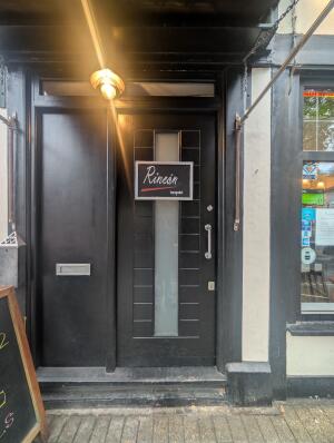 Black wooden door in front. Silver metal handle on right. Push to open.