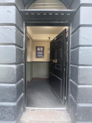 Black wooden door. Push left side to open.