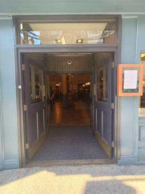 Glass doors with grey, wooden frames. Push from middle to open.