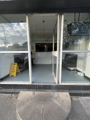 Glass door with a white frame and handle on left. Push to open.