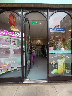 Glass door with black, metal frame. Push from right to open.