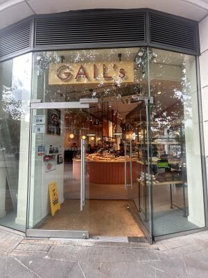 Glass doors with glass frames ahead. Push metal bar in center to open.