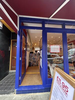 Glass doors with blue frames ahead. Push lever handle on right to open.