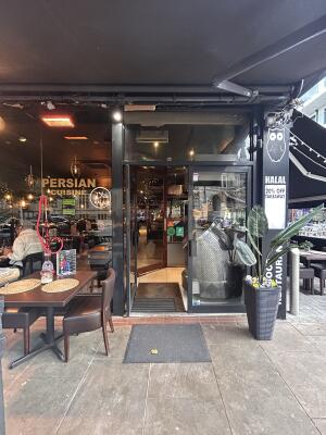 Black framed glass door against glass wall. Push left door from centre to open.