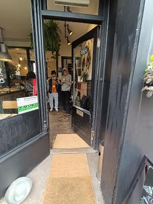 Glass door with black, wooden frame. Push from handle on left to open.