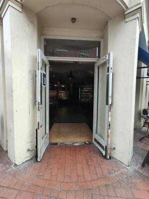White framed glass door. Pull silver metal handles in centre to open.