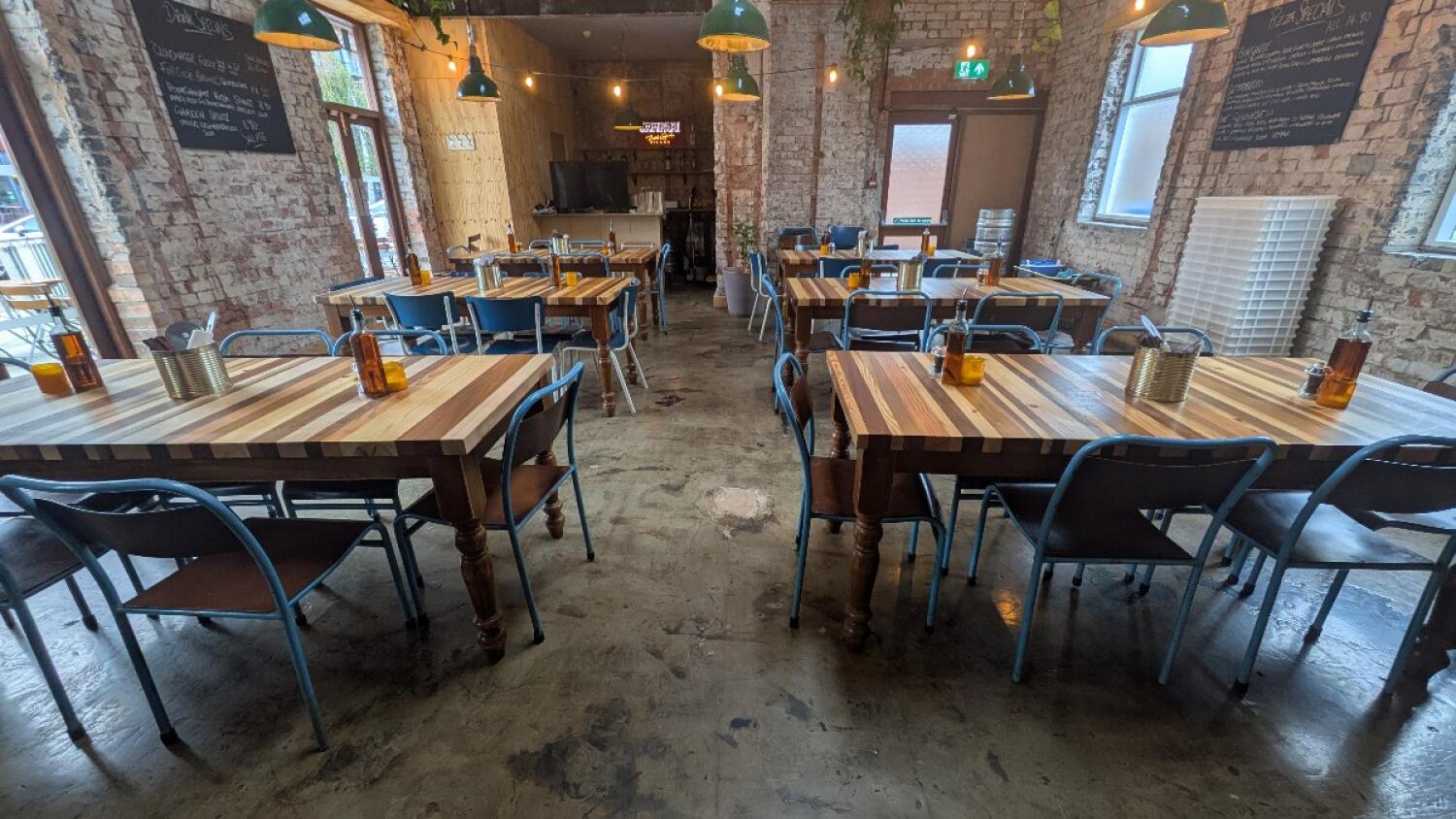 From doorway facing straight. Tables and chairs along both sides.