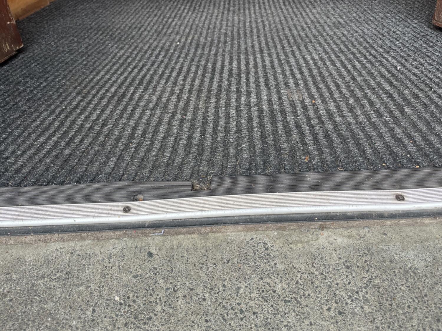 Metal bump at end of ramp up, followed by a carpet.