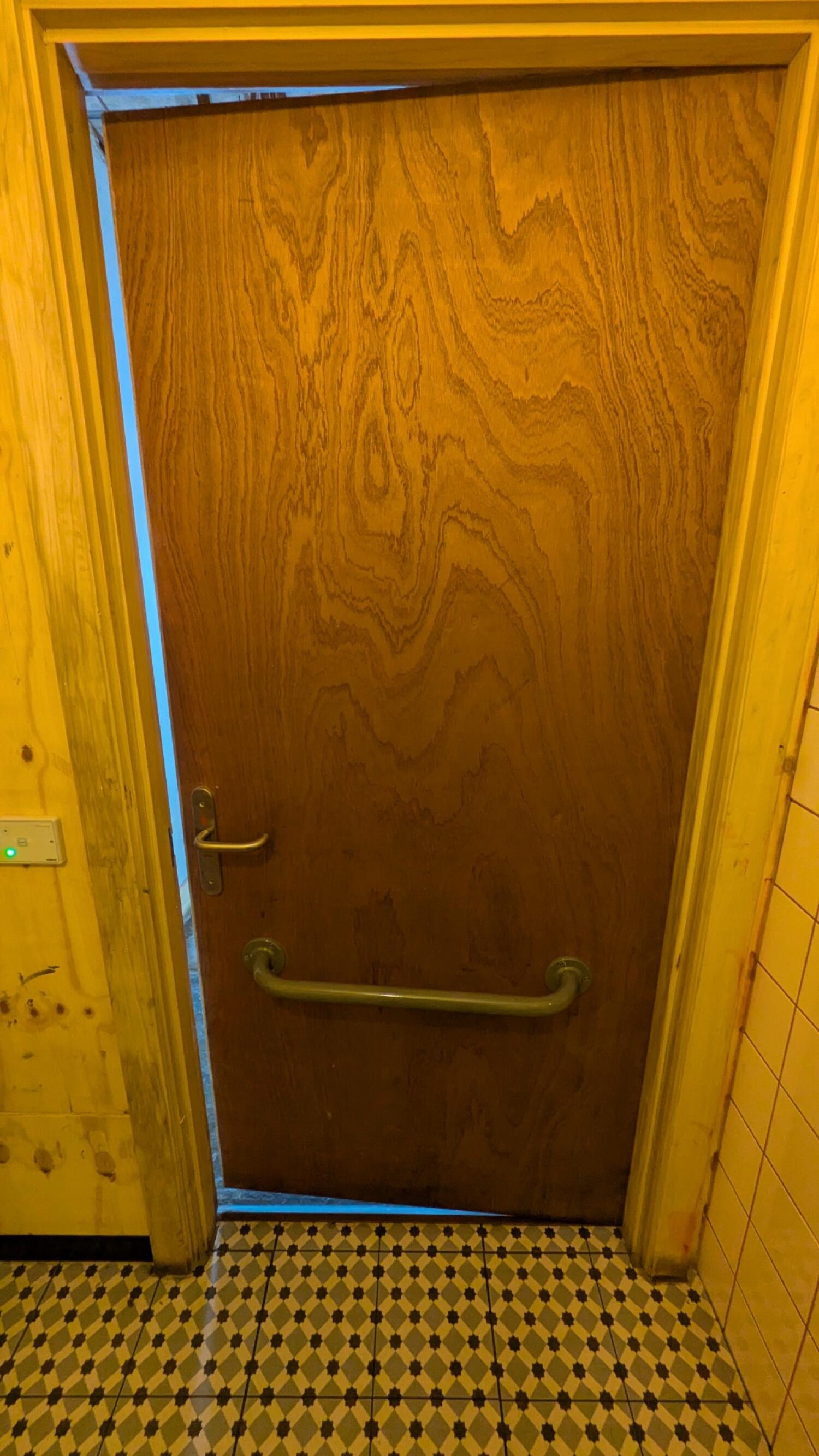 Back of toilet door. Lock on left. Grab rail in center