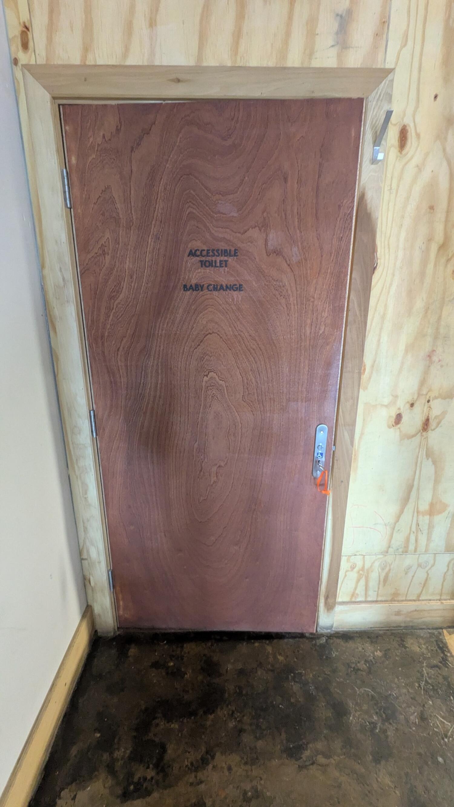 From back right of side area facing right. Wooden toilet door. Pull handle on right to open.