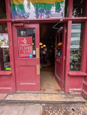 Red wooden doors with glass panels. Gold metal pads in center. Push to open.