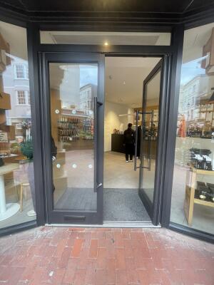 Glass doors with black frame ahead. Push black handles from centre to open.