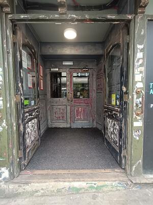 Glass doors with black, wooden frames ahead. Push from middle to open.