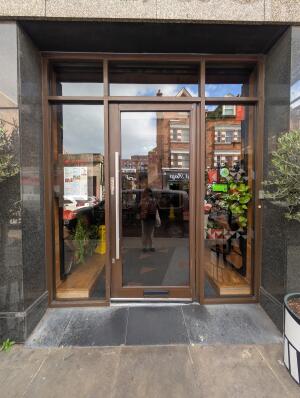 Brown frame glass doors in front. Silver metal handle on left. Pull to open.