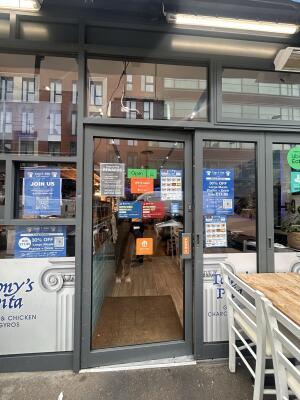 Glass door with grey metal frames ahead. Push from the right to open.