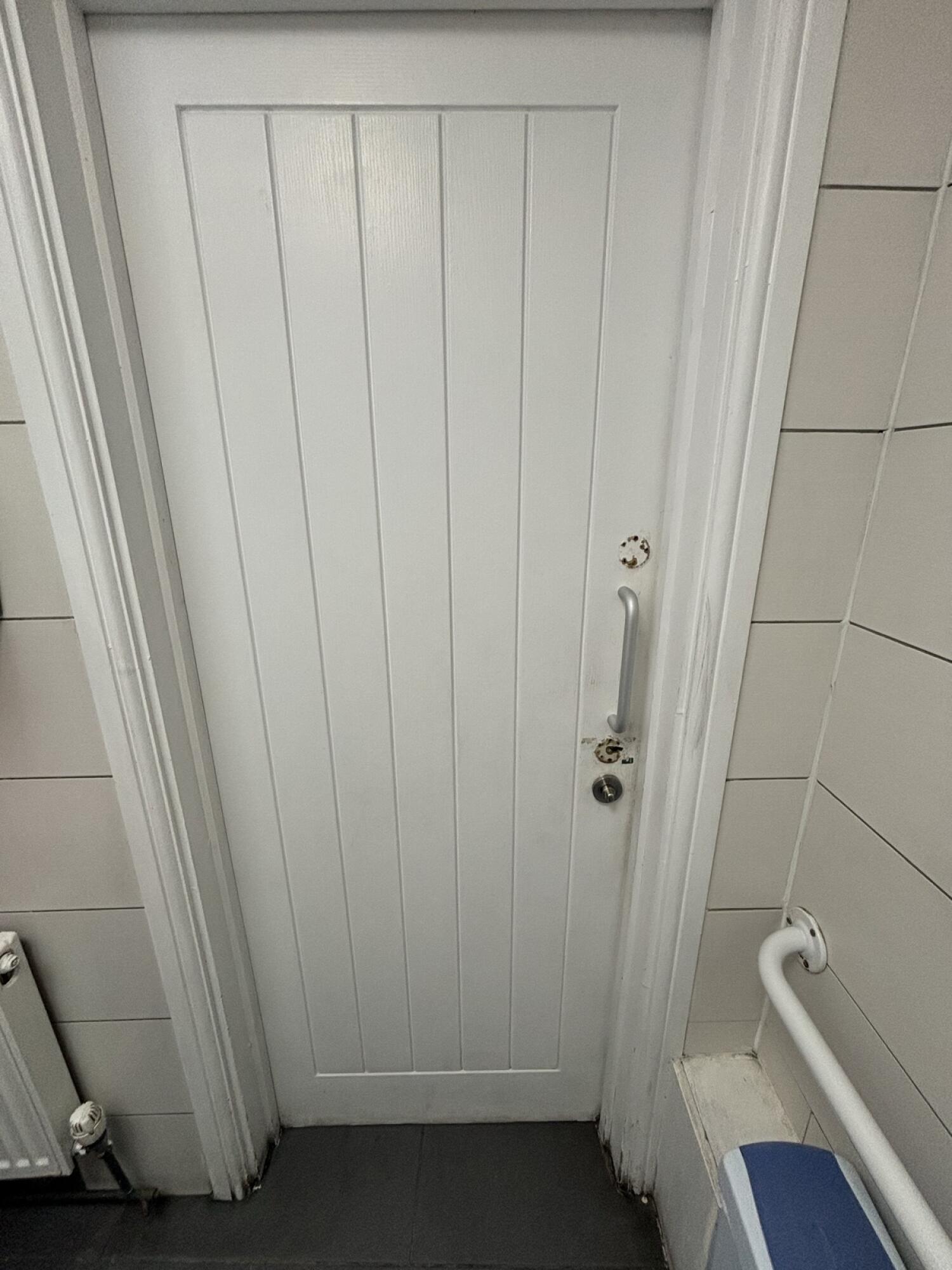 From back of door. Silver handle on right. Push to open.