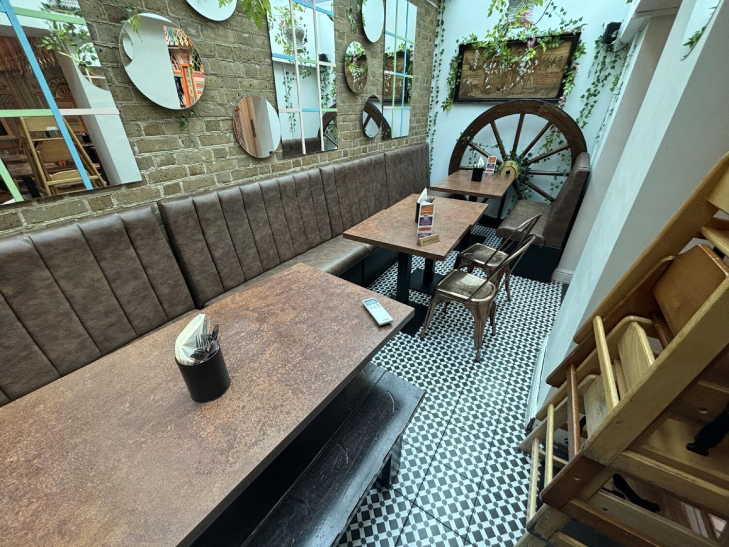 From opening facing slightly right. Half booths, chairs and bench along back wall. Booth at back.