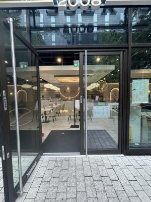 From street facing venue. Black framed glass doors ahead. Pull doors from handles in centre to open.