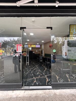 Glass door with glass frames ahead. Push metal bar on right to open.