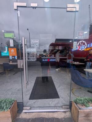 Full glass doors in front. Silver metal handle on left. Push to open.