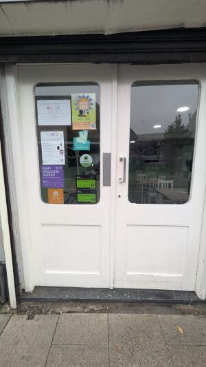 Glass doors with white frame. Push handle in center to open