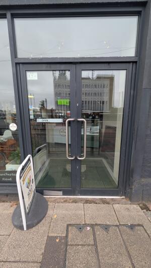 Glass doors with black frame. Push handles in center to open.